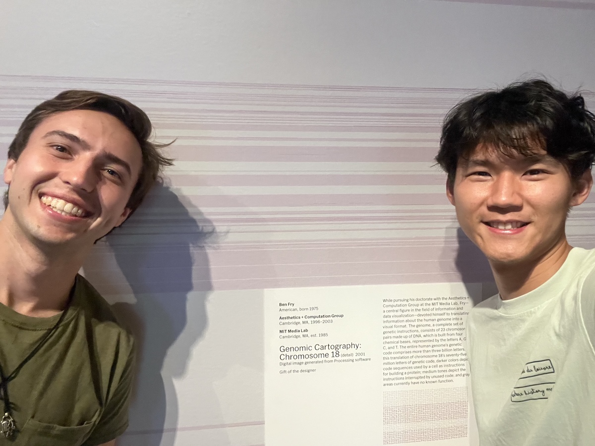 Chase and his roommate in front of the exhibit wall